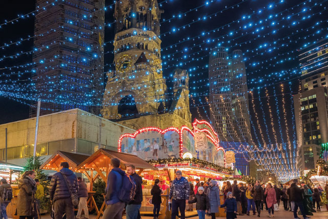 The Christmas market near Zoologischer Garten in Berlin with the Gedächtniskirche and blue lights.