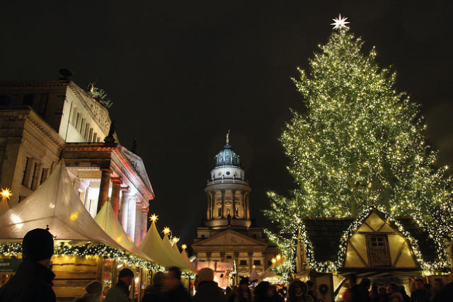 The Christmas tree and the Christmas market stalls in front of the French cathedral in Gendarmenmarkt.