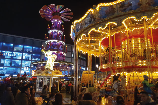 The Alexanderplatz Christmas Market in Berlin with its carousel and traditional wooden pyramid.