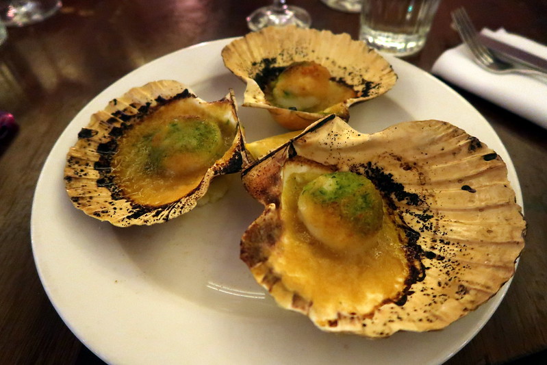 Three scallops on a white dish served at Hawksmoor restaurant in London