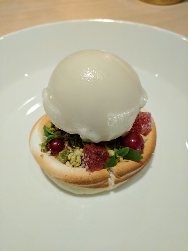 Artistic dish with ice cream, pistachio, and berries in Stockholm's Hillenberg restaurant.