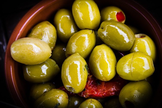 Brown bowl containing Greek green olives.