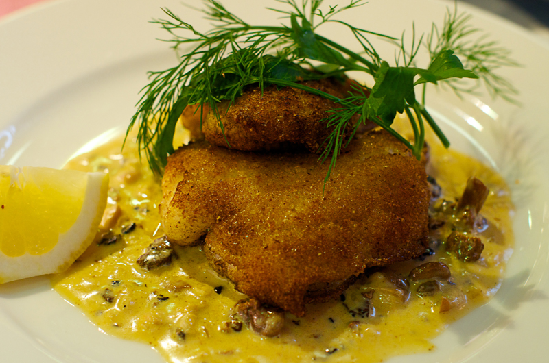 Breaded fish with lemon and sauce in the Lisa Elmqvist restaurant located inside the old Östermalms saluhall market.
