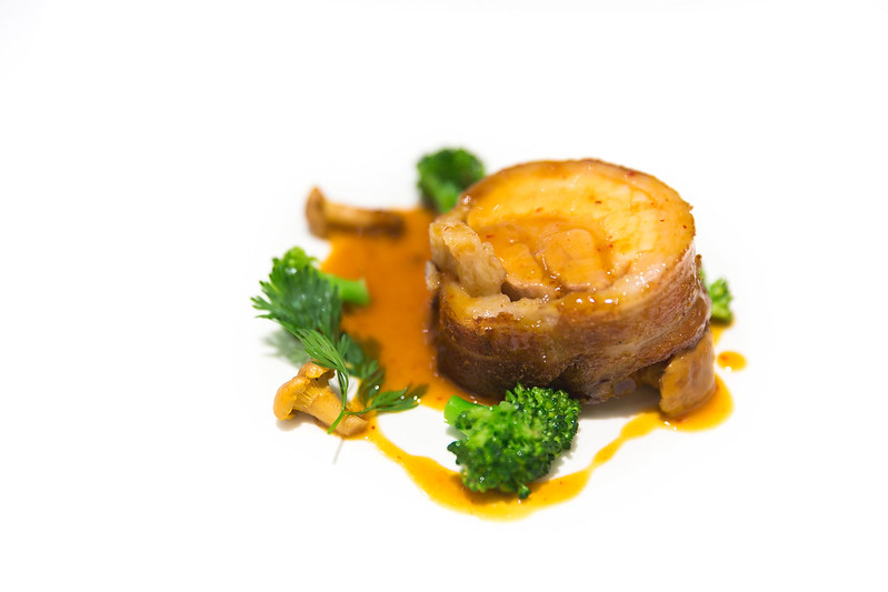 Meat with caramelized sauce, mushrooms, and parsley tufts prepared at the Michelin Guide restaurant Gresca in Barcelona.